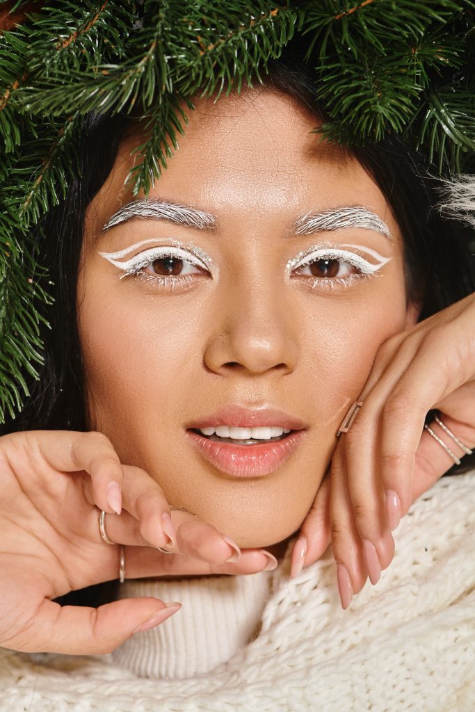 winter beauty, close up of happy asian woman with green wreath posing in scarf and looking at camera