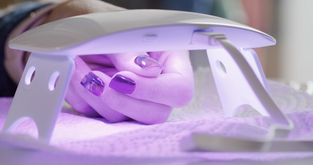 Woman make her manicure at home. UV Nail Lamps. home manicure. nail polish.