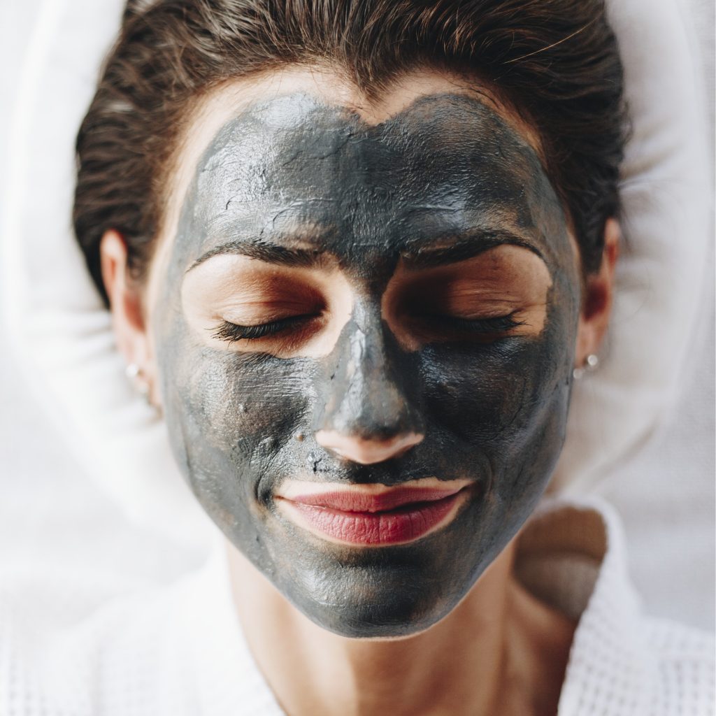 Woman relaxing with a charcoal facial mask