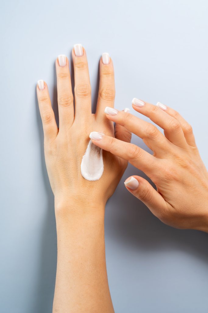 Woman smudging hand or body cream gel serum on her hands, body care concept. lotion. lotions. skincare. after wax lotion.