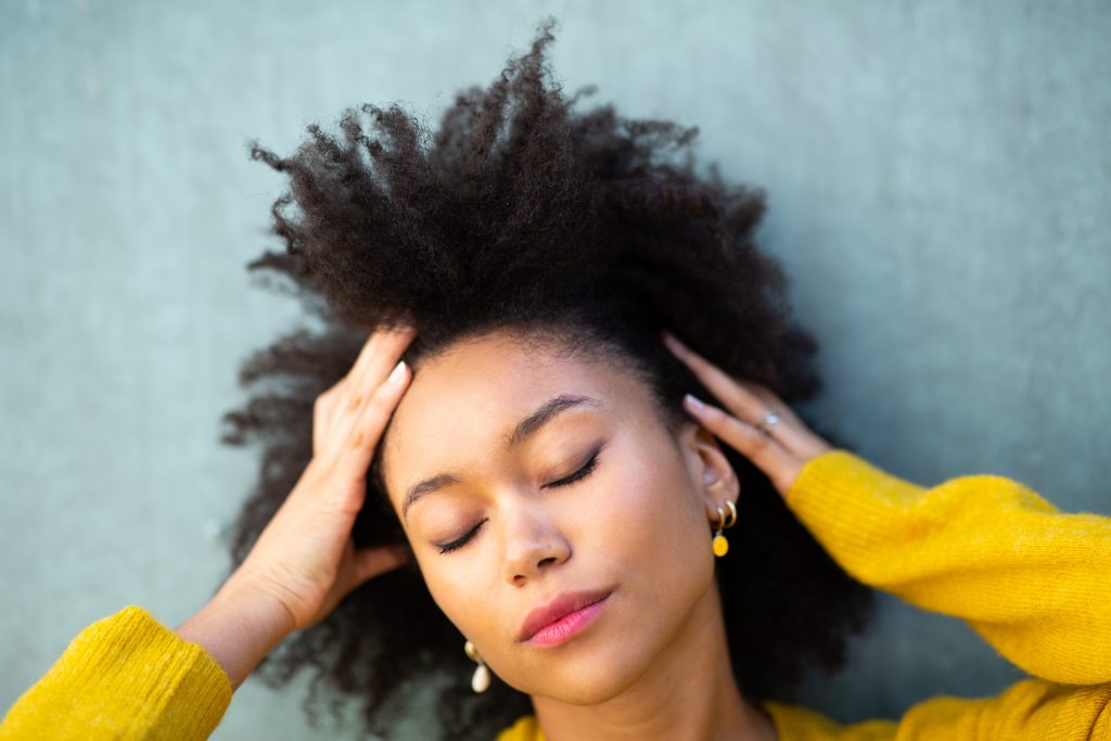 stress affects your skin. Close up portrait of beautiful young black woman with eyes closed and hand in hair