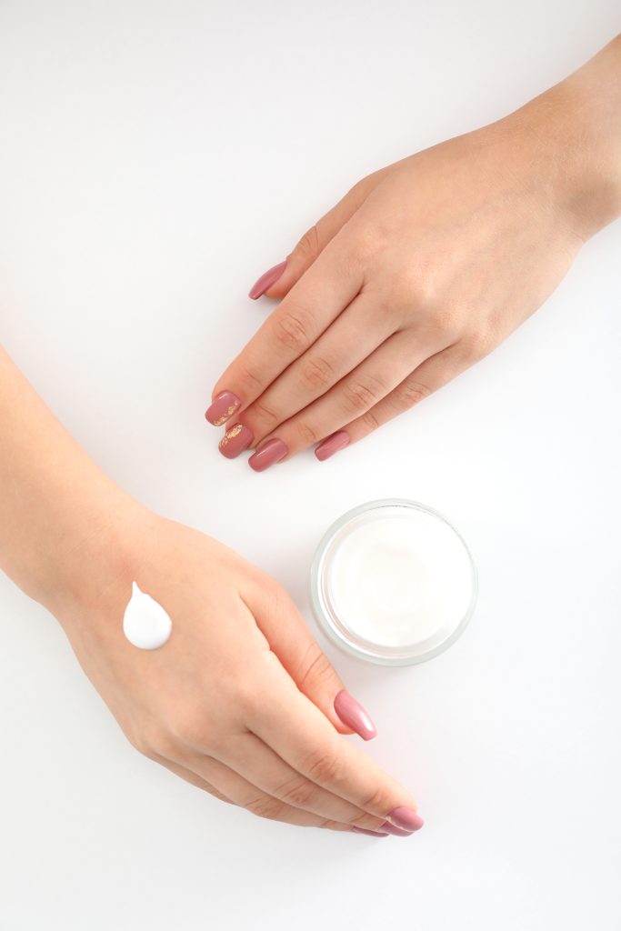 Concept of hand care with cosmetics on white background