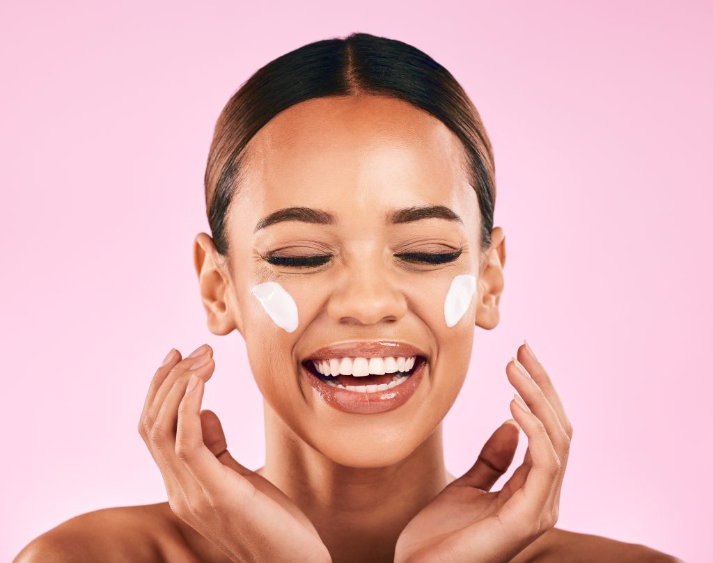 Hands, face and skincare of woman in studio with beauty cream, cosmetics product or dermatology on. Morning Routine.