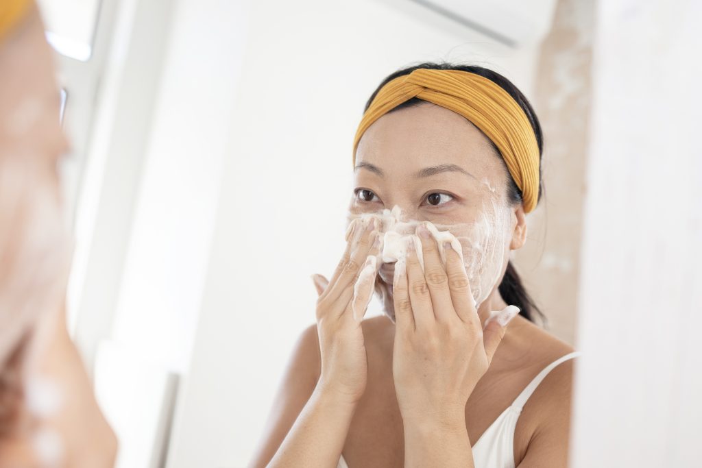 smiling woman washing her face. foam cleanser