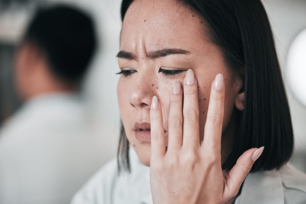 Stress, headache and scientist woman in laboratory working with microscope, tech and pharmaceutical. Signs That Stress Is Affecting Your Skin.