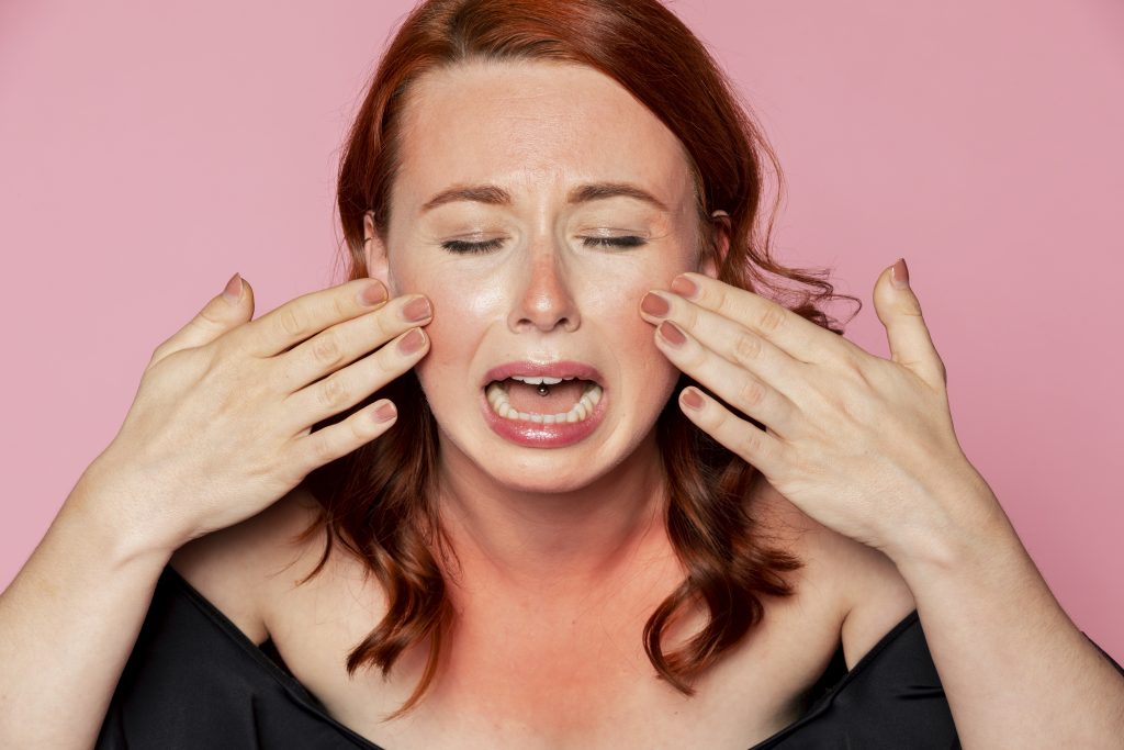 Woman crying over sunbunt skin. Common Skin Problems Caused by Stress.