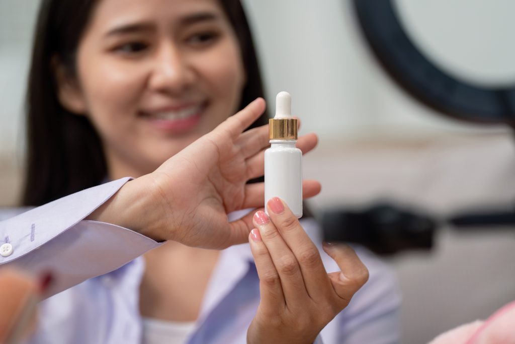 niacinamide for skin. A beauty broker enthusiastically presenting a skincare serum in a live broadcast, highlighting the product's features and benefits to viewers.
