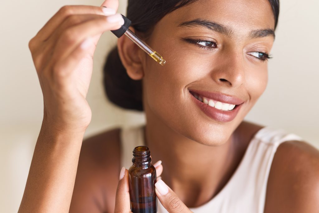 Skincare Serenity: A Woman Joyfully Applying Facial Serum, Capturing Beauty And Radiance. Highlighting Self-Care, Wellness.