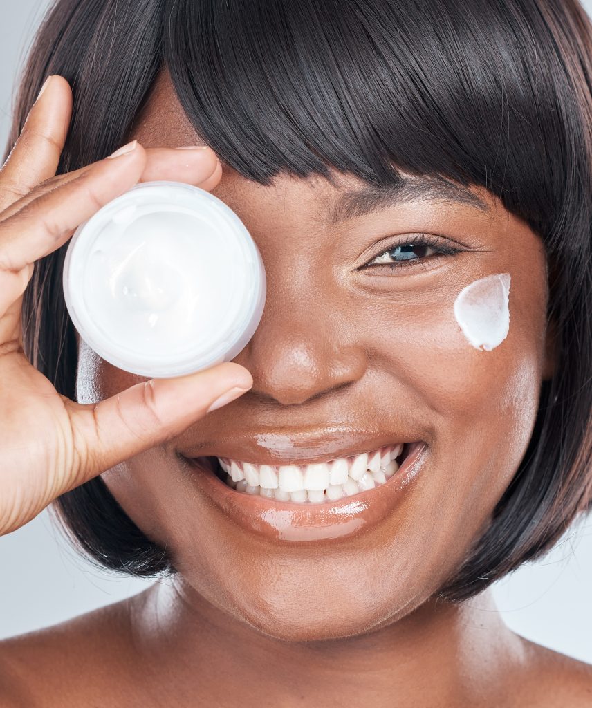 Under Eye Cream. Studio shot of an attractive young woman applying moisturiser to her face against a grey background.