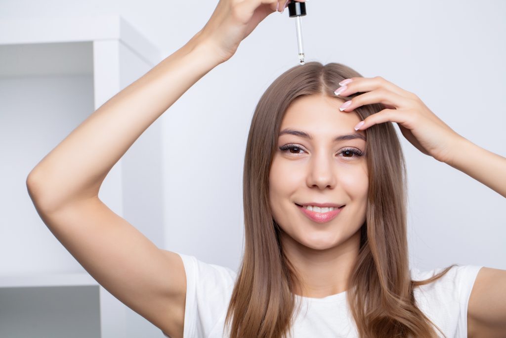 woman with beautiful hair, applies vitamins for hair growth. woman with beautiful hair, applies vitamins for hair growth. 