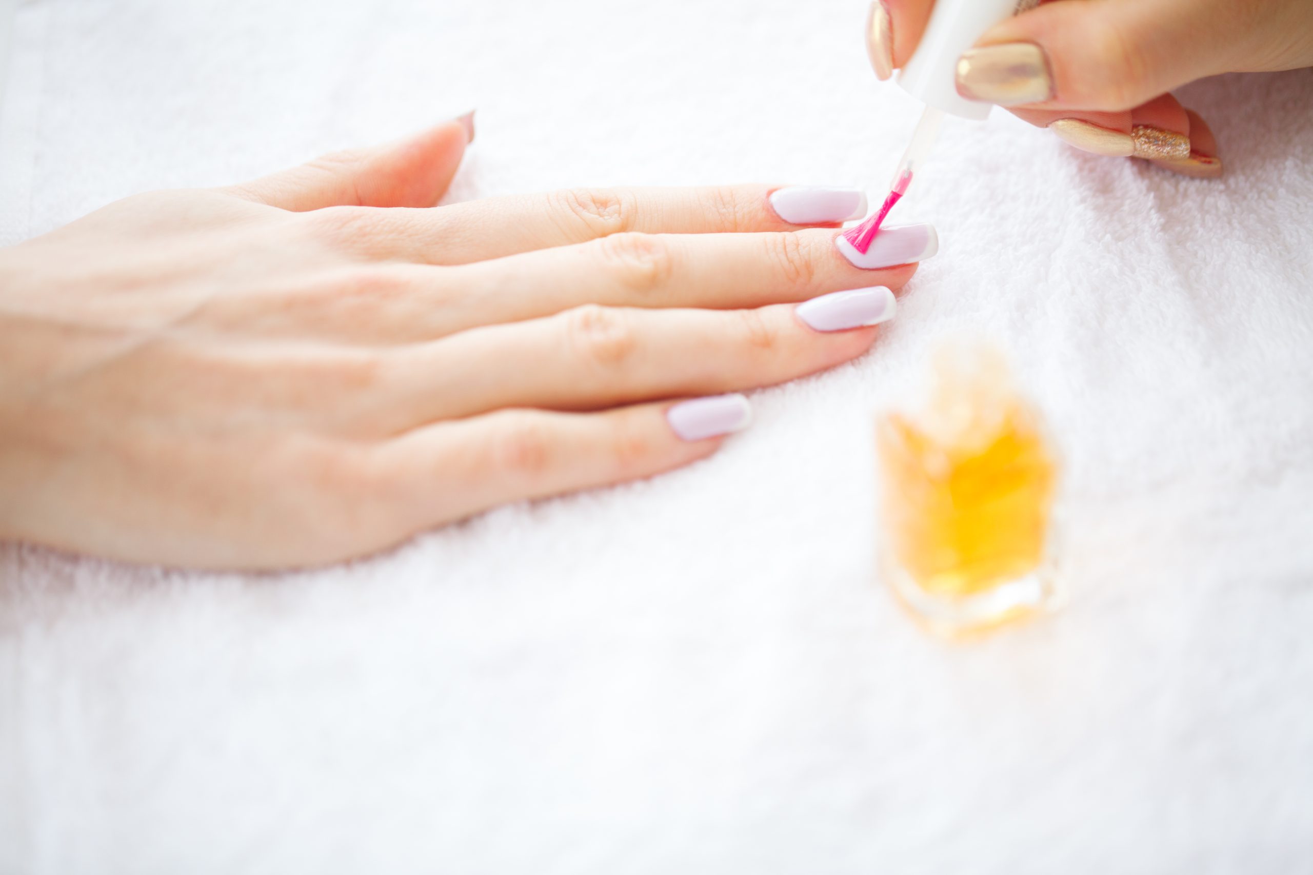 Nail Recovery After Gel. Beauty and Care. Beautiful Women's Hands with Perfect Manicure. Manicure Master Applying Nail Polish in a Beauty Salon. Beauty Day. Spa Manicure. Hand and Nail Care.