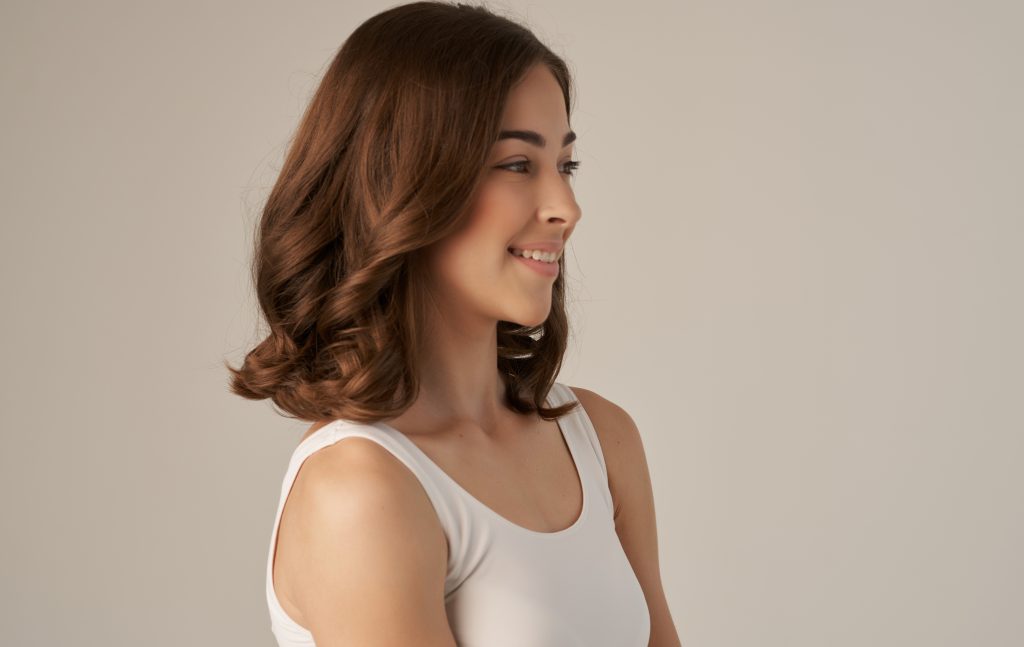 pretty brunette in white t-shirt smile emotions beige background. High quality photo