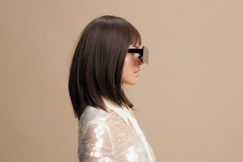 Woman, white shirt, sunglasses a stylish woman in a white shirt and sunglasses with her hair parted to the side, gazing thoughtfully into the distance