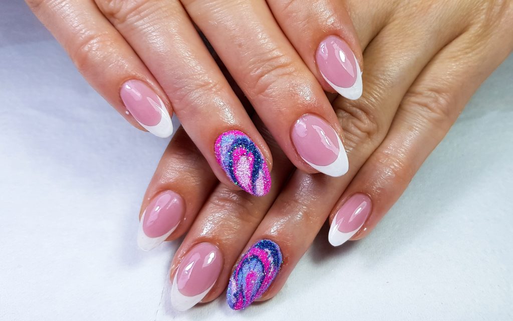 A closeup of oval-shaped nails with a french manicure and colorful design
