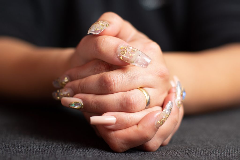 A closeup shot of female hands with trendy glossy manicure on her nails