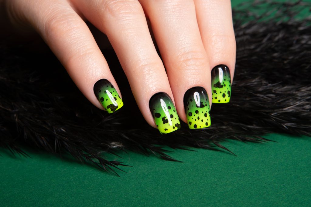 Female neat hand with short natural nails painted with green nail polish. Natural, cozy, elegant, modern look. High-quality photo