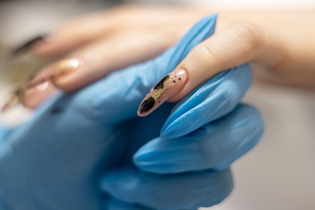 Acrylic Nails. Manicure session in a nail salon. Nail polish.