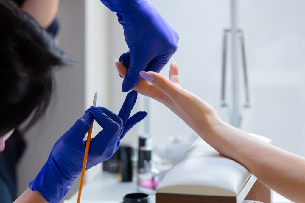 manicure master applying a nail polish