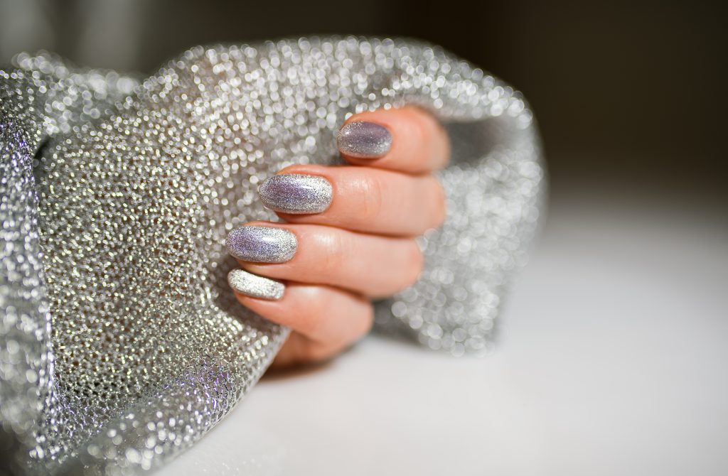 Nails Design. Hands With Bright Silver Christmas Manicure. Close Up Of Female Hands. Art Nail.