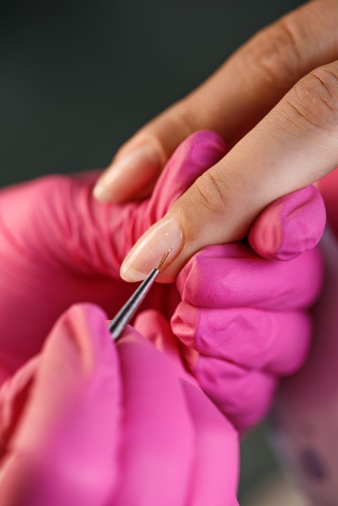 beautician applying Polish nails to woman nails. manicure process