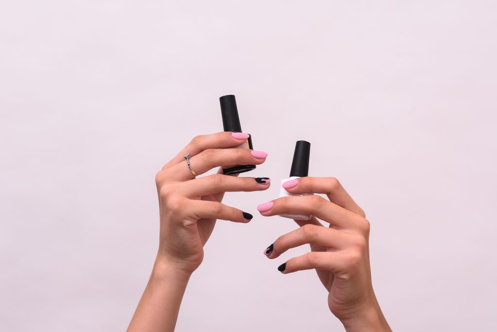 How Long Do Gel Nails Last – Pro Tips for 21+ Days of Wear. Nail polishes in the hands of a white girl on a white background. High quality photo.