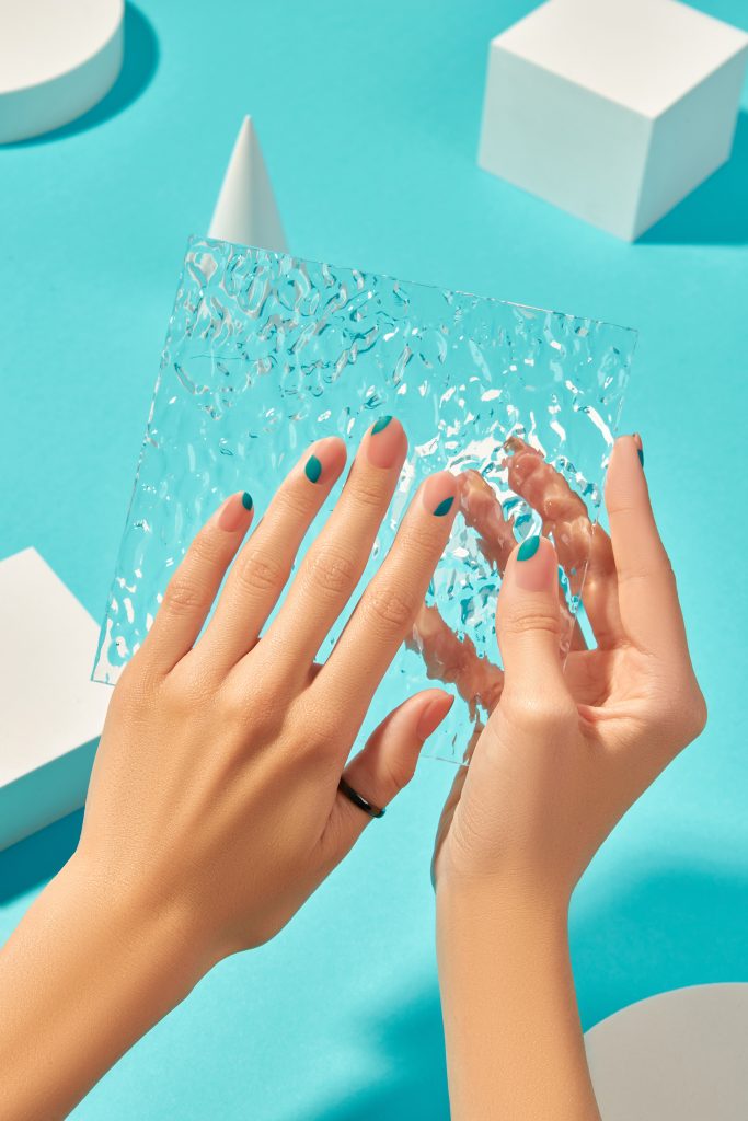 Trendy bright yellow nails with black speckled "eggshell" effect on medium-length oval nails.