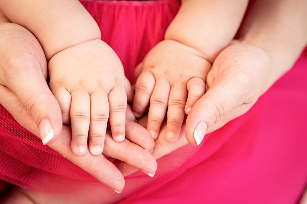 parent hands holding newborn baby fingers, Close up mother's hand holding their new born baby hands. Love family concept