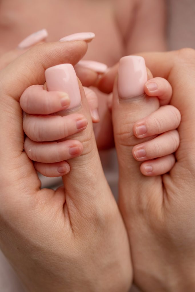 The hand of a newborn in the mother's hand. Mom and her child. Happy family concept. Beautiful concept image of motherhood.