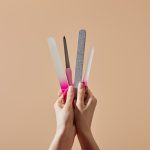 Cropped view of woman holding nail files and emery board isolated on beige. Nail File Types