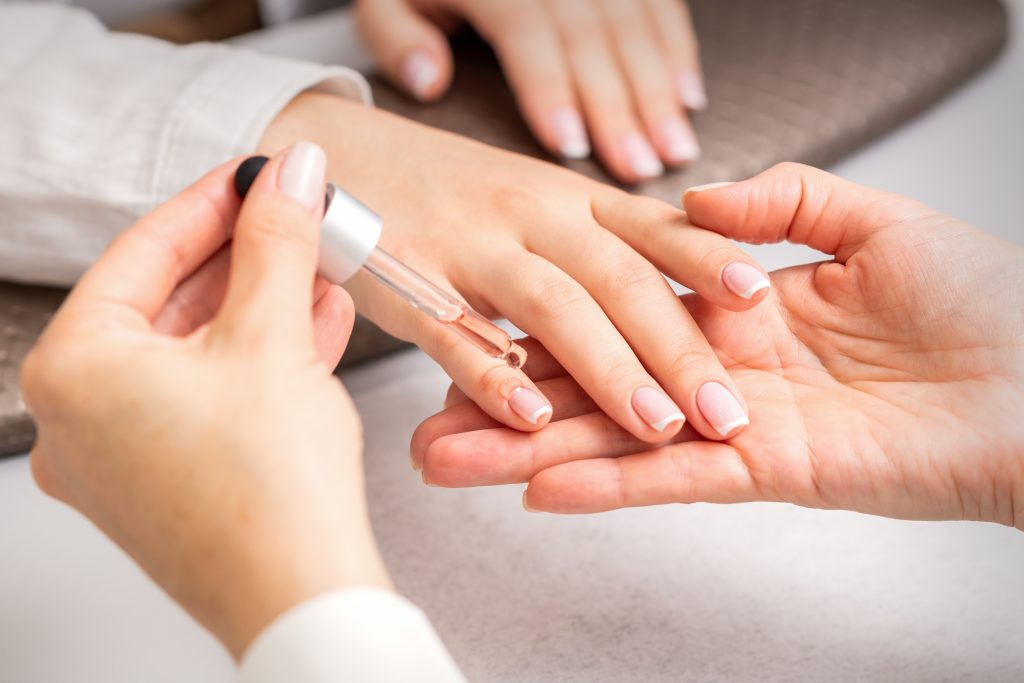 Nail care routine, applying nail care treatment at home.