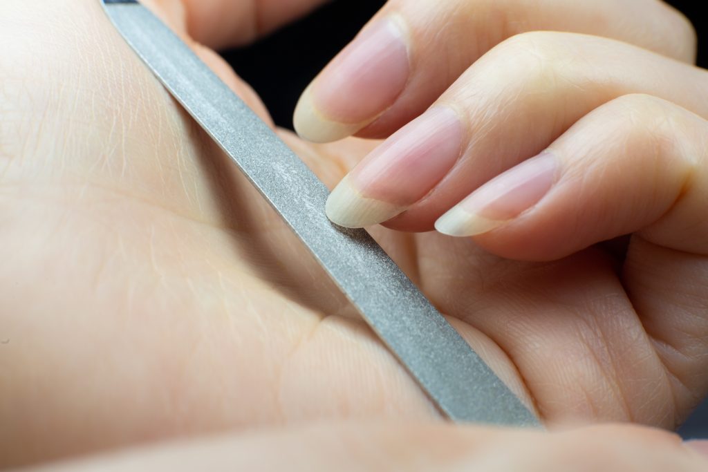 Woman makes herself a manicure at home. Nail file. 