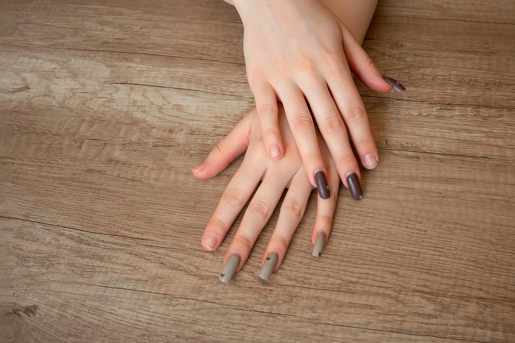 female hands close-up with regrown broken nails. lack of manicure on the hands, groomed female hands