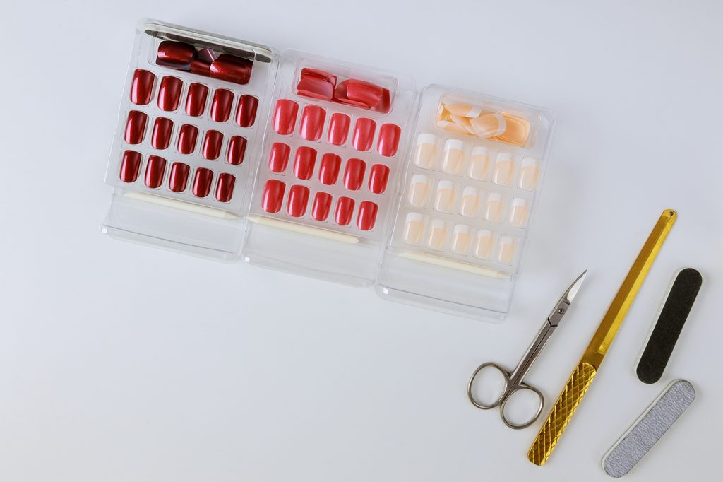 Several palette of nail designs of different colors on a light background.